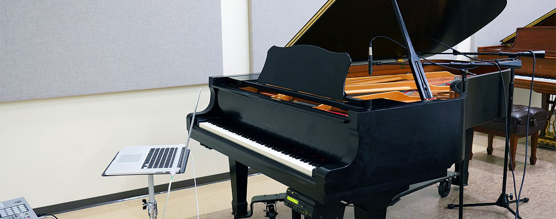 Grand piano Disklavier with a laptop in front